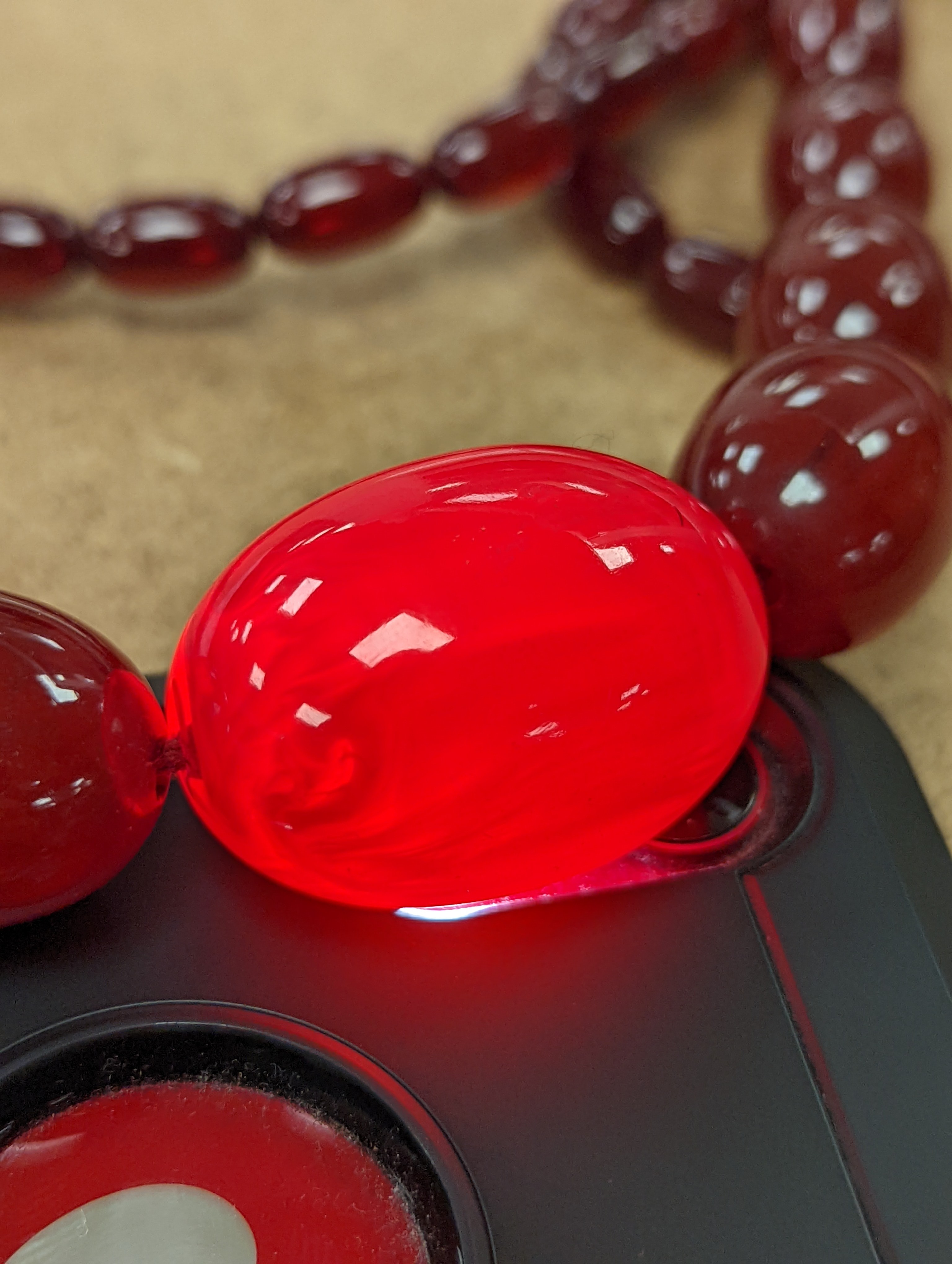 A single strand graduated simulated cherry amber bead necklece, 72cm, gross weight 63 grams.